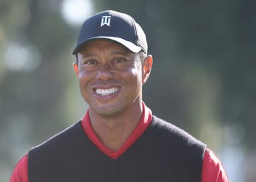 tiger woods smiling at the conclusion of a golf tournament