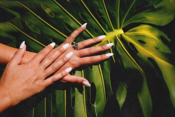 a woman's hand holding a yellow flower