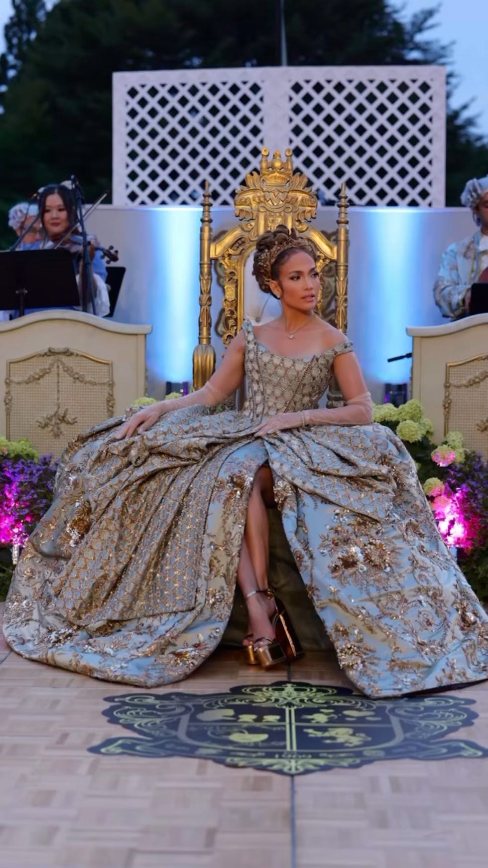 jlo in a dress sitting on a throne