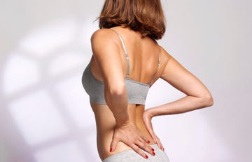 woman massaging her painful back due to sports injury