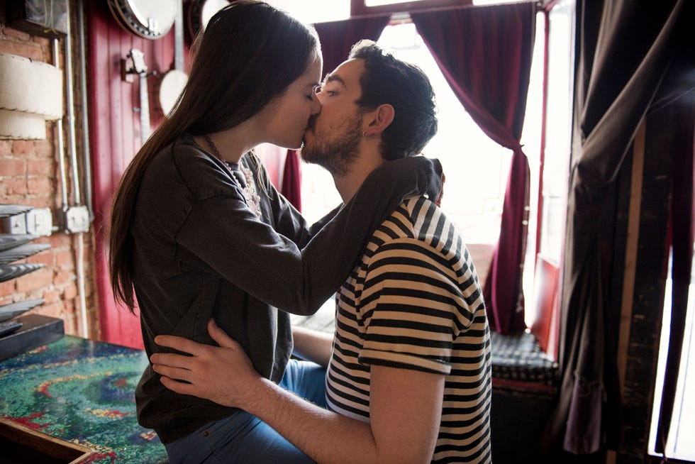 young couple kissing in coffee shop