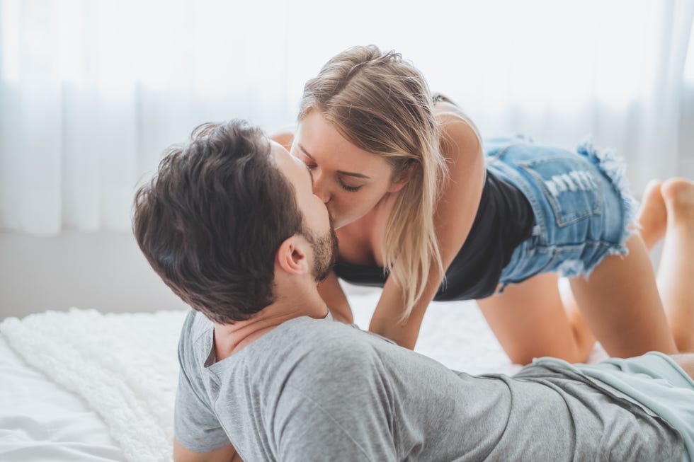 young couple kissing on bed