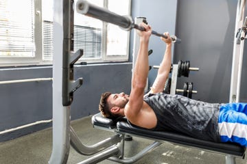 young handsome man is doing exercises in a gym