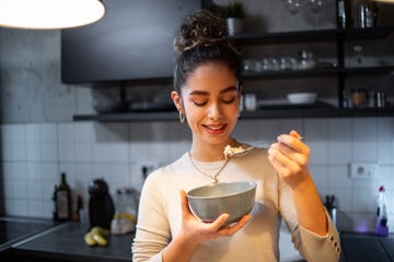 a young woman eats oatmeal