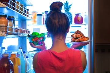 young woman making choices for a healthy salad or junk food fried chicken