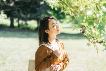 young woman relaxing in nature with eye closed