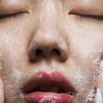 young woman washing face, close up