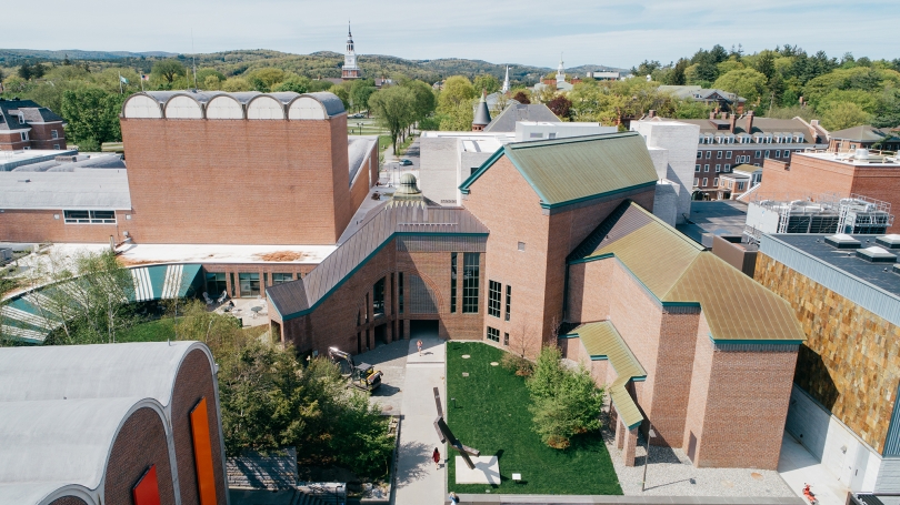 An aerial view of a college campus surrounded by forests and mountains.