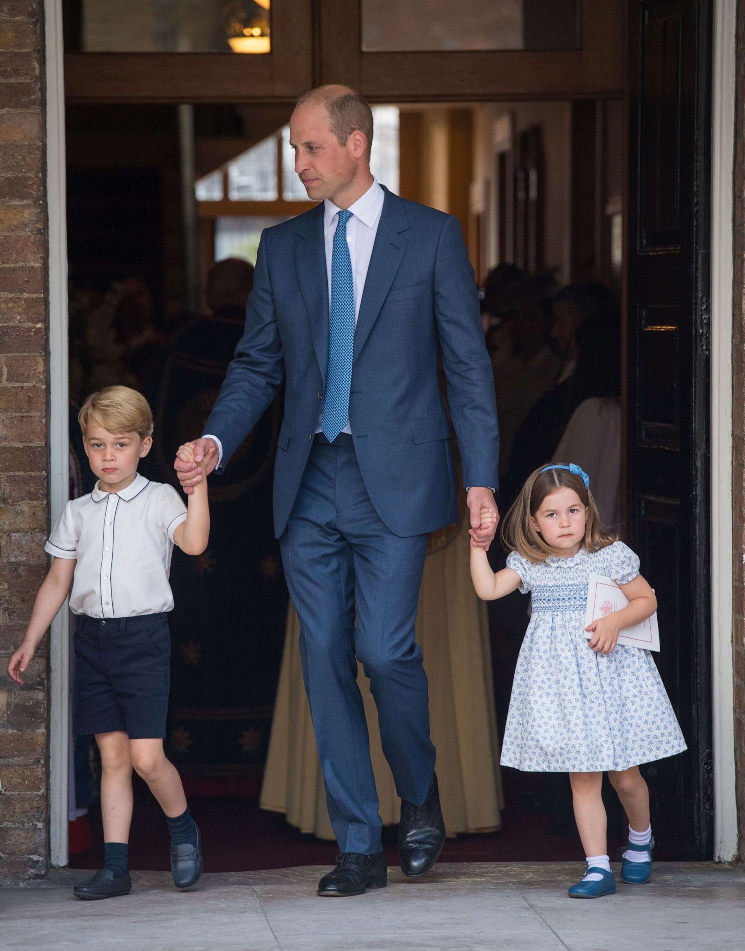PHOTO: Prince William, Duke of Cambridge with Prince George and Princess Charlotte depart after attending Prince Louis' christening at the Chapel Royal, St James's Palace on July 9, 2018, in London.