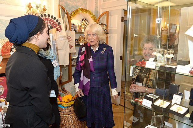 Adding a little glitz to her sophisticated attire, Prince Charles' wife donned two vibrant floral brooches on her elegant blazer