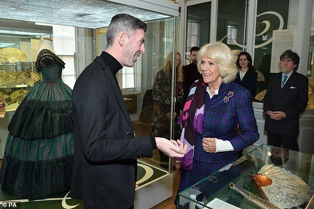 Camilla added to her bright ensemble with a crisp white shirt, and a vibrant, multicoloured scarf, which sat across one of her shoulders