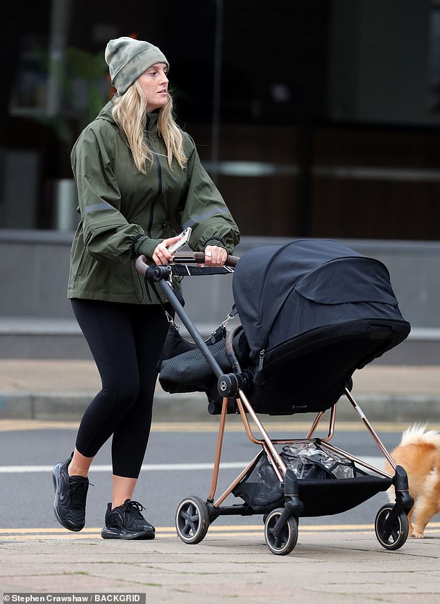 Trendy: Donning a pair of onyx trainers, she covered her gorgeous blonde waves with a bleached green beanie hat