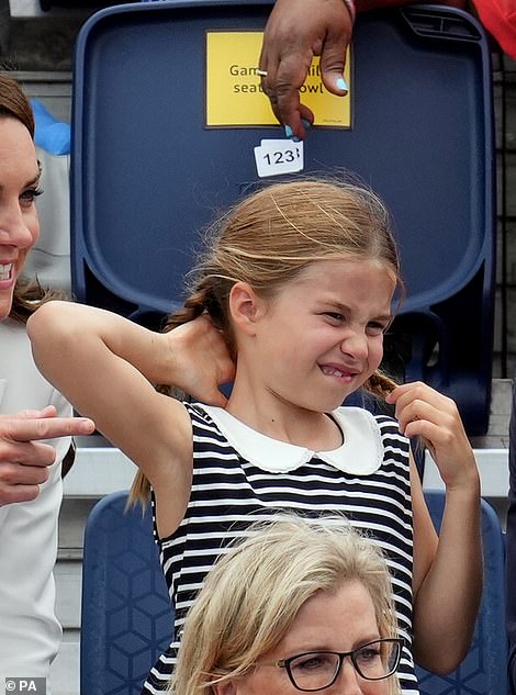 Playing with her plaits! During the outing, the seven-year-old began playfully tugging at her long plaits, while her parents watched the match