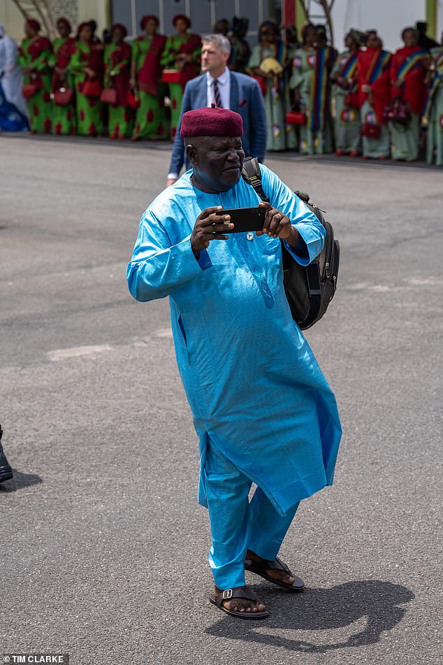 People outside Nigeria's Defence Headquarters in Abuja as the Sussexes arrive today