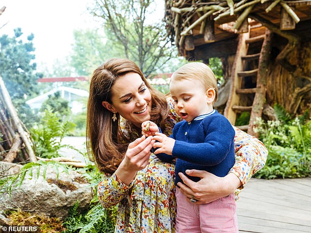 Toddler Louis looked fascinated as he held a stone, while Kate, kneeling at his side, wrapped her arm around her youngest child