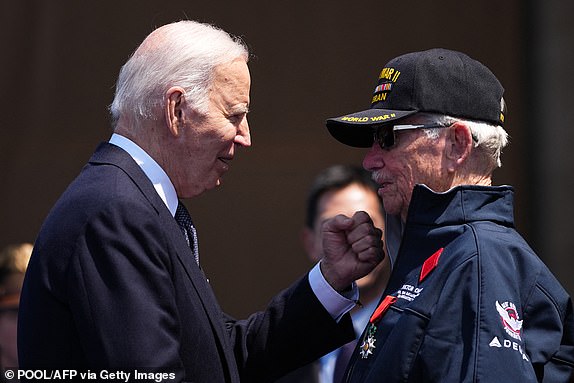 President Joe Biden greets US WWII veteran Victor Chaney with the insignia of the Chevalier de la Legion d'Honneur (French Legion of Honour) during the US ceremony marking the 80th anniversary of the World War II "D-Day" Allied landings in Normandy, at the Normandy American Cemetery and Memorial in Colleville-sur-Mer, which overlooks Omaha Beach in northwestern France, on June 6, 2024. The D-Day ceremonies on June 6 this year mark the 80th anniversary since the launch of 'Operation Overlord', a vast military operation by Allied forces in Normandy, which turned the tide of World War II, eventually leading to the liberation of occupied France and the end of the war against Nazi Germany. (Photo by Daniel Cole / POOL / AFP) (Photo by DANIEL COLE/POOL/AFP via Getty Images)