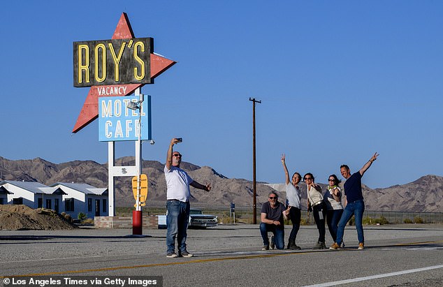 French tourists take a group selfie on National Trails Highway (Route 66) in front of the Roy's sign on May 24, 2024