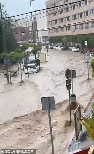 Water is seen gushing down the streets of Murcia on Monday as the south-eastern region of Spain was hit by torrential rain