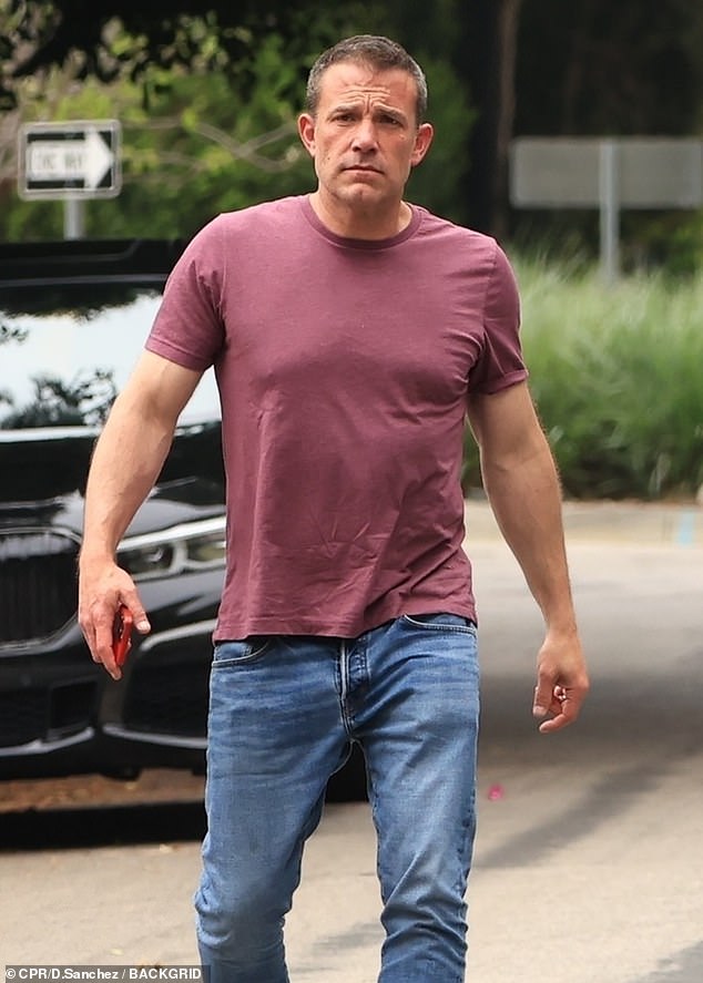 He wore a burgundy T-shirt and jeans for the outing as he strode down the street