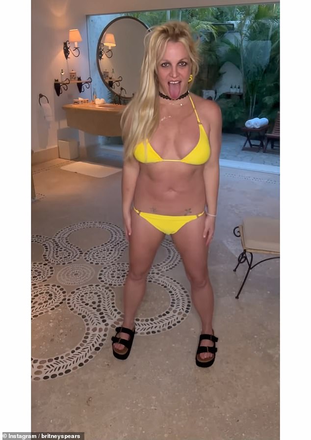 Rocking a skimpy yellow bikini, Britney struck poses in her room's sprawling master bathroom