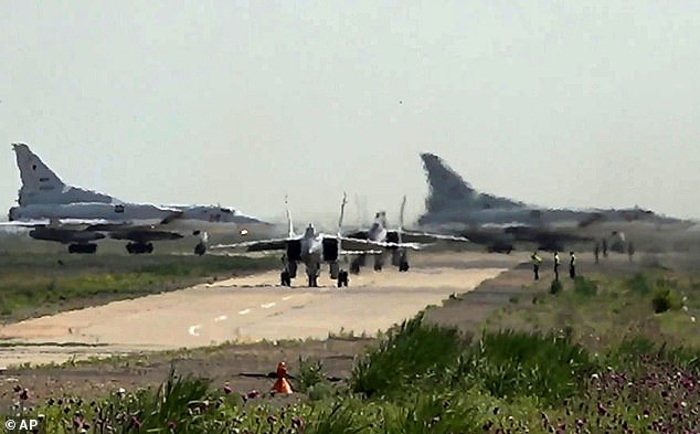 A pair of MiG-31 fighter jets of the Russian air force taxi out for a training mission with two Tu-22M3 bombers seen in the background during joint Russian-Belarusian drills intended to train the military to use tactical nuclear weapons