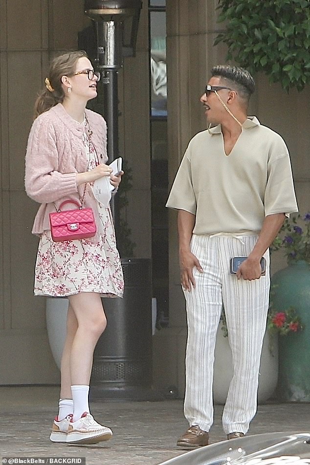 Violet was spotted outside wearing a pink sweater, dress, and trainers with quilted purse slung across her body