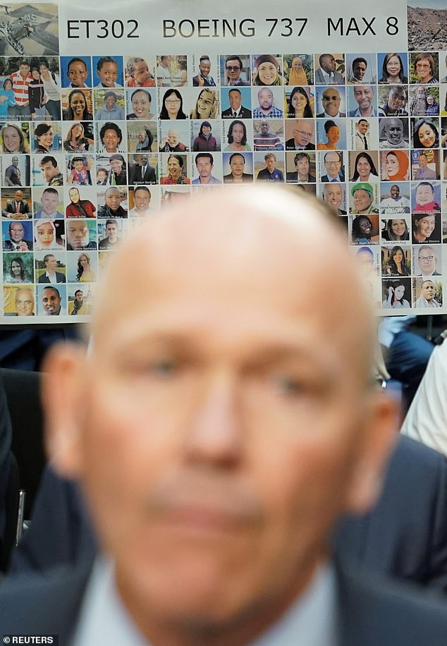 A placard with photos of those killed on Ethiopian Airlines Flight 302 is held up as Boeing's CEO Dave Calhoun testifies before the Senate