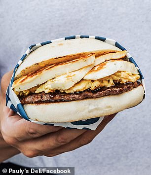 A giant breakfast sandwich with cevapi and scrambled eggs