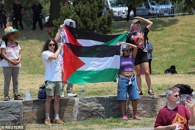 Supporters stand holding Palestinian flags at Jamaal Bowman's campaign rally