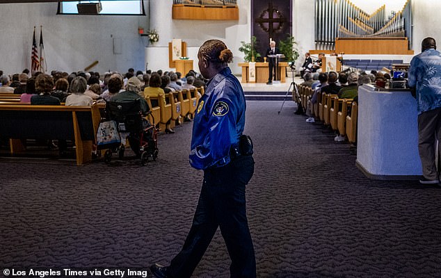 An armed security guard stands at the back of the church during the one-year anniversary memorial service for the Laguna Woods/Irvine Taiwanese Presbyterian Church shooting on May 14, 2023