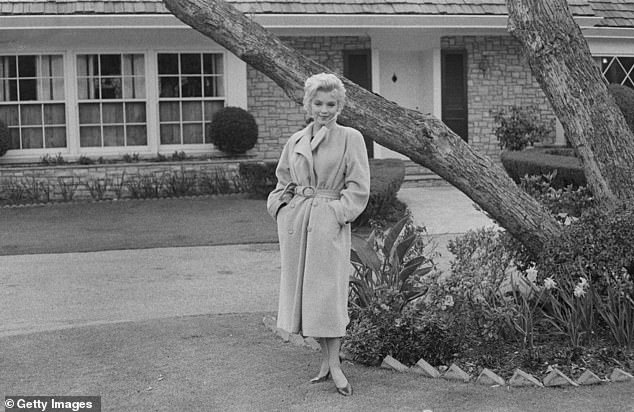 Monroe poses outside her home in 1962, it was the only property she ever purchased and owned by herself