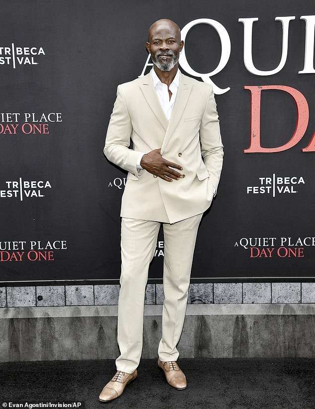 The Beninese-born 60-year-old - who plays Henri - looked dapper in a beige double-breasted suit, white button-up sans necktie, and brown Oxfords selected by stylist Cheryl Konteh