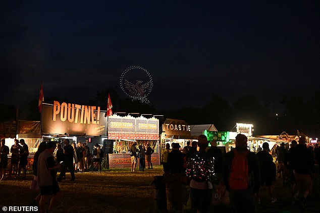 Revellers watch a drone show at Worthy Farm in Pilton, Somerset for the Glastonbury Festival last night