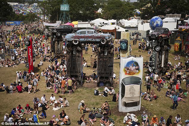 Festival goers at Carhenge during the Glastonbury Festival on Worthy Farm, Somerset