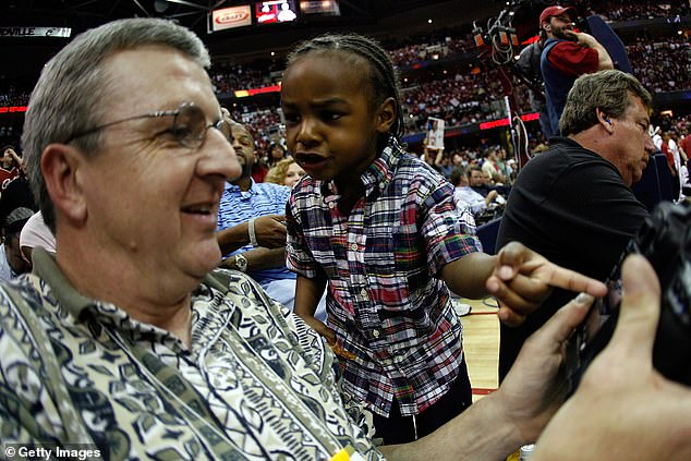 A young Bronny looks at a picture of his father on David Heritsch's digital camera in 2007