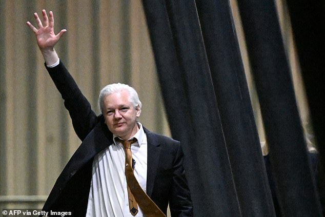 Assange waves after arriving at Canberra Airport in Canberra on June 26, 2024