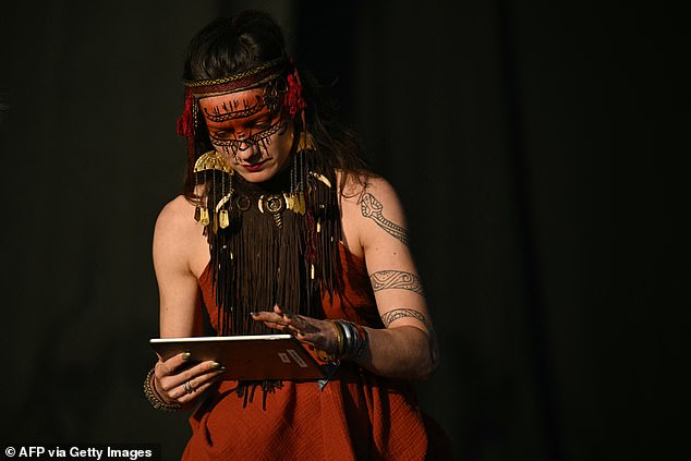 A member of experimental folk music band Heilung fixes an iPad error during their performance on the West Holts stage