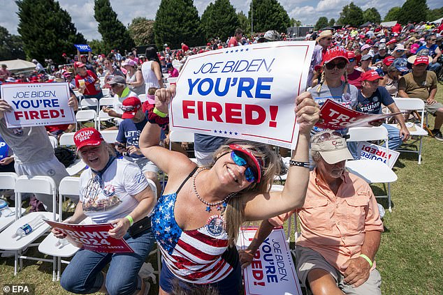 Republicans hold up signs bearing Trump's famous catchphrase from the Apprentice directed towards his political foe