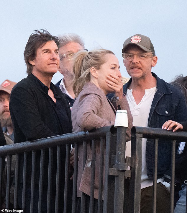 The Top Gun star cut a smart figure in a black open collar shirt while Simon rocked a white T-shirt with a navy jacket and a baseball cap