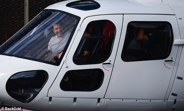 Cruise was seen sharing a laugh with others that were also inside the helicopter as they landed in central London