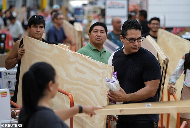 People buy wood to protect their windows as they prepare ahead of the arrival of Hurricane Beryl, in Cancun, Mexico on June 30, 2024