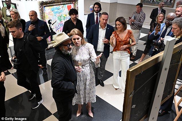 Beatrice looked to be in deep conversation as she and Mr Brainwash took in the artworks around them