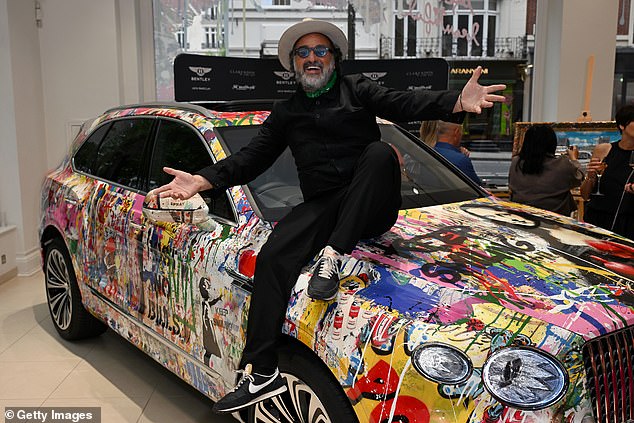 The artist posed on the painted over car, as excited attendees took in the colourful exhibit this evening