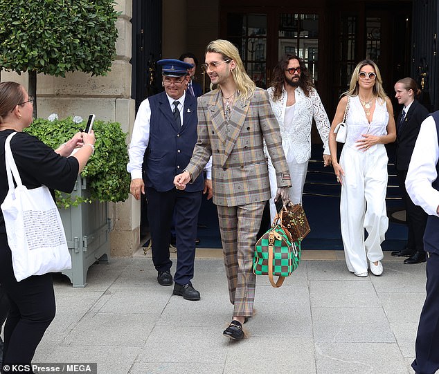 Tom, 34, coordinated his outfit with his wife, looking handsome in a white tank top under a cutout lace shirt, while his brother and Tokio Hotel bandmate Bill put on a very dapper display in a double-breasted plaid suit