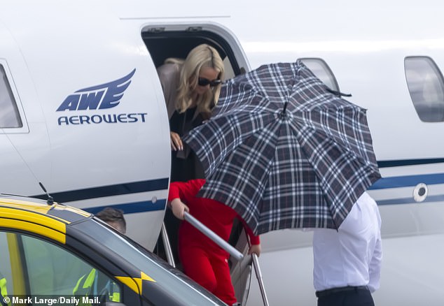 The squadron of planes were carrying WAGs including goalkeeper Jordan Pickford's wife Megan (pictured), 28, – seen hiding behind an umbrella held by a crew member