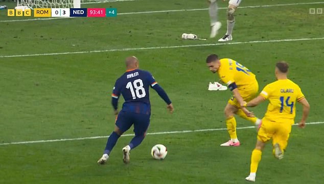 The shoes were precariously placed inside Romania's penalty area as Donyell Malen cut inside