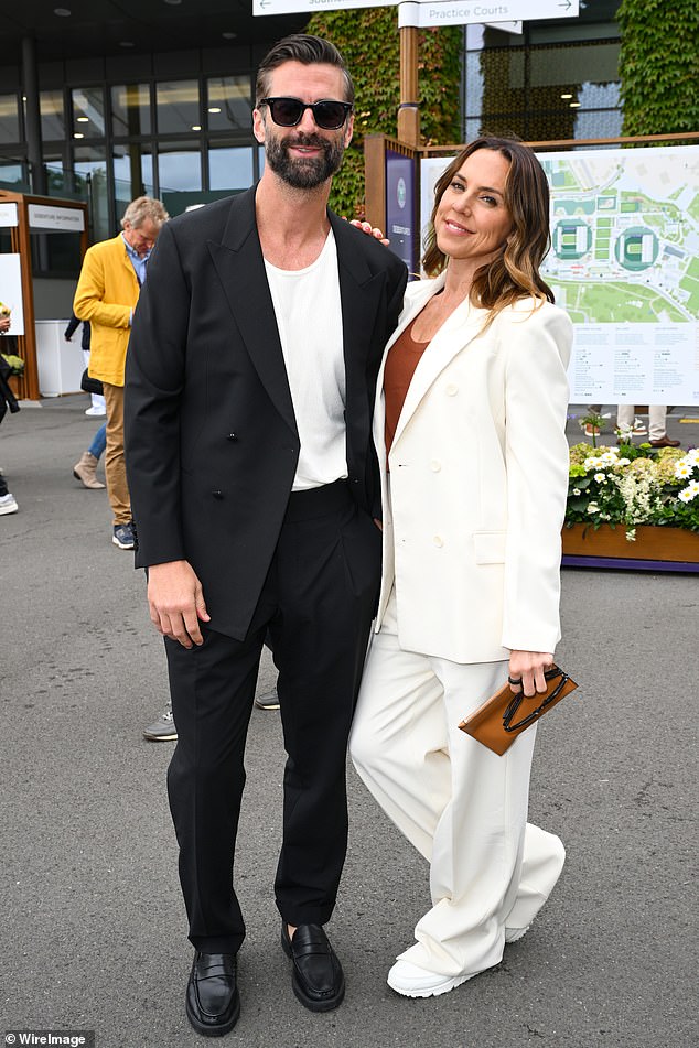 For the day out Mel looked effortlessly chic in a white trouser suit and orange vest top, while accessorising with a camel clutch purse