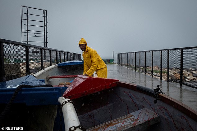 A fisherman checks the boats he secured as Hurricane Beryl approaches, in Kingston, Jamaica