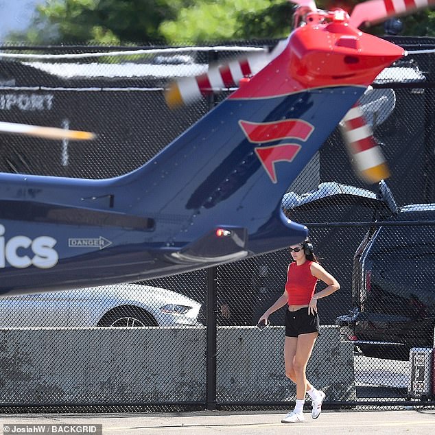 The 28-year-old fashionista put her taut midriff and endless legs on display as she strutted her stuff towards a waiting helicopter