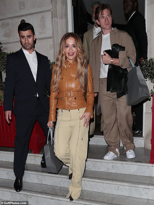 She completed her outfit with a pair of wide-leg cream trousers and accessorised with a sleek brown bag